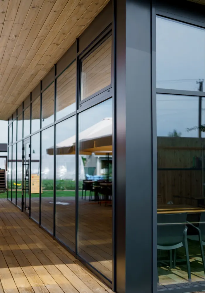 The exterior of a barndominium constructed of steel & wood with large glass windows